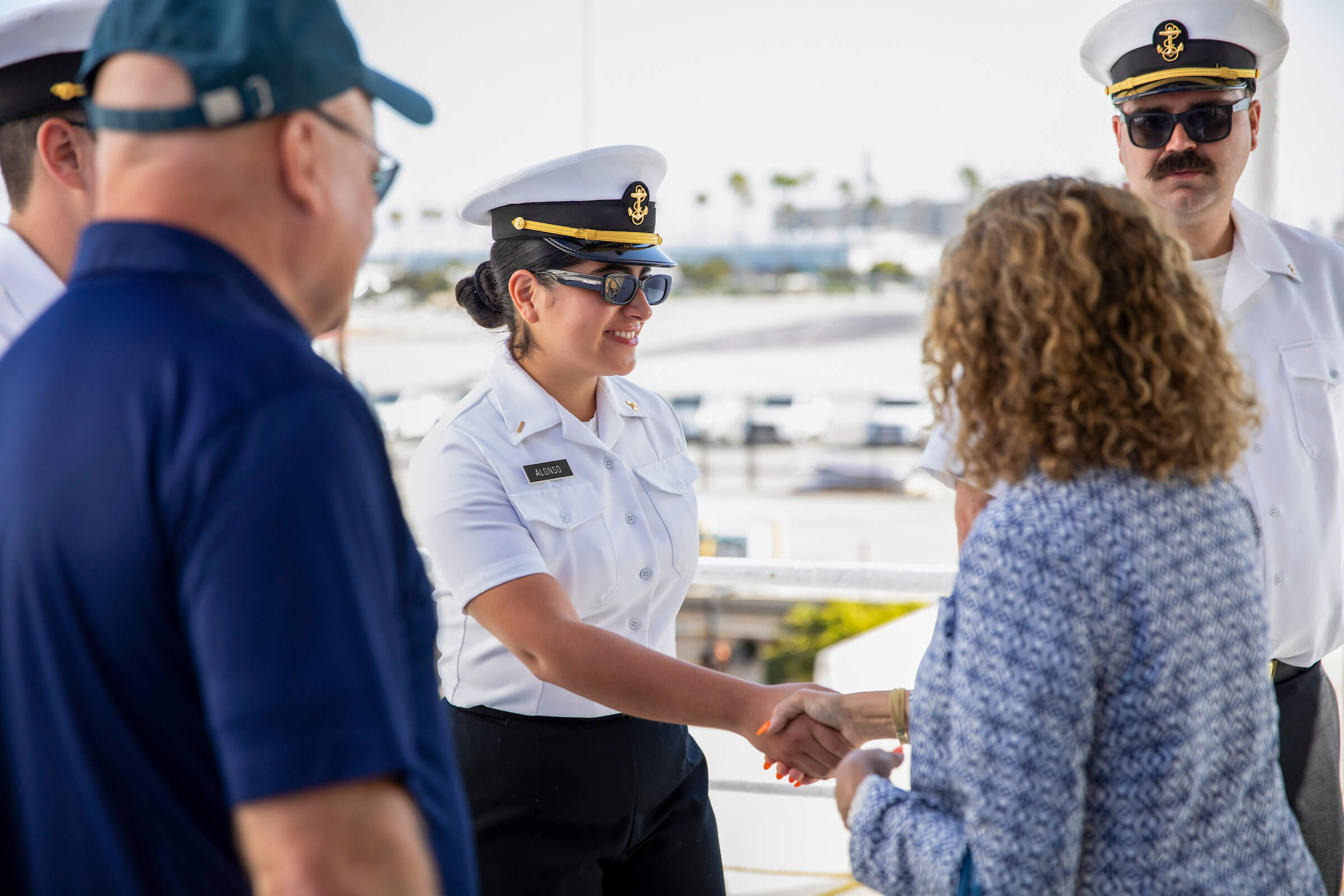a cadet in uniform shaking hands with someone