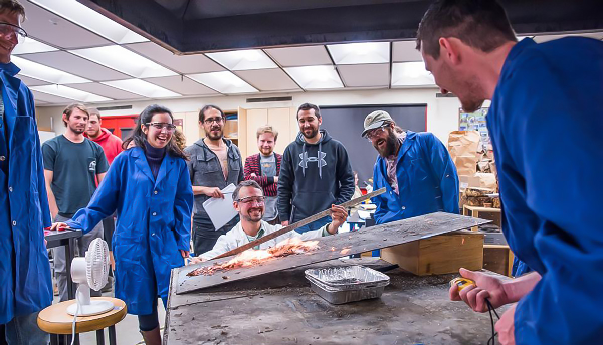 college students watch a wildfire demonstration in a lab
