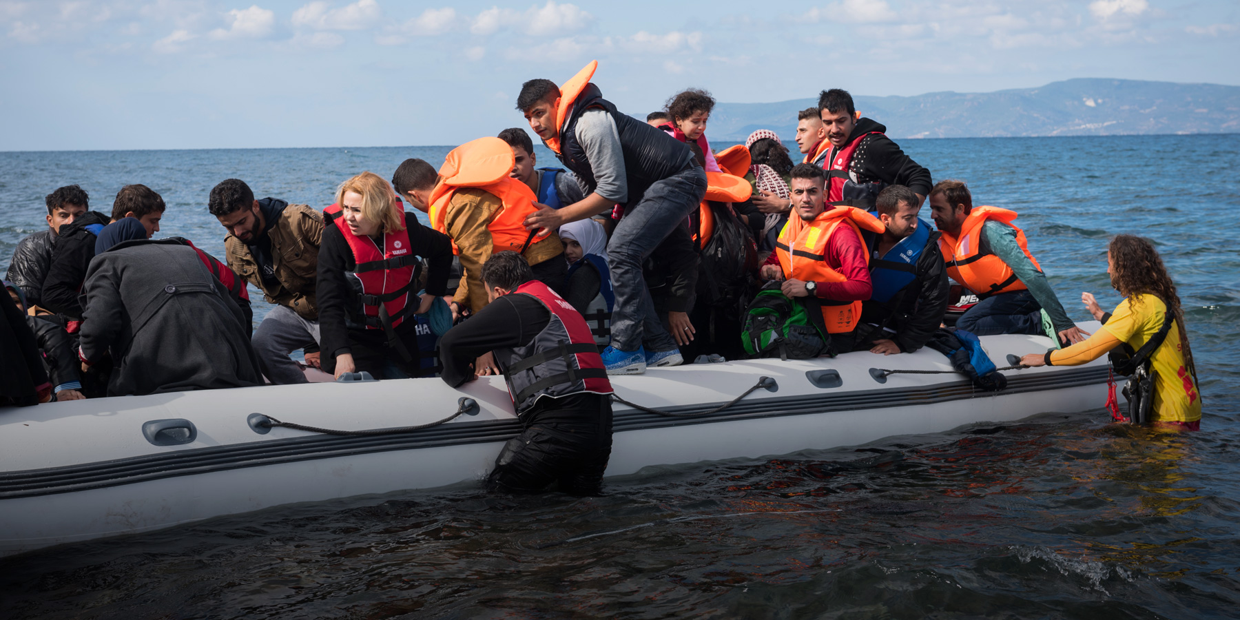 large group of people in a rubber raft concerned looks on their faces
