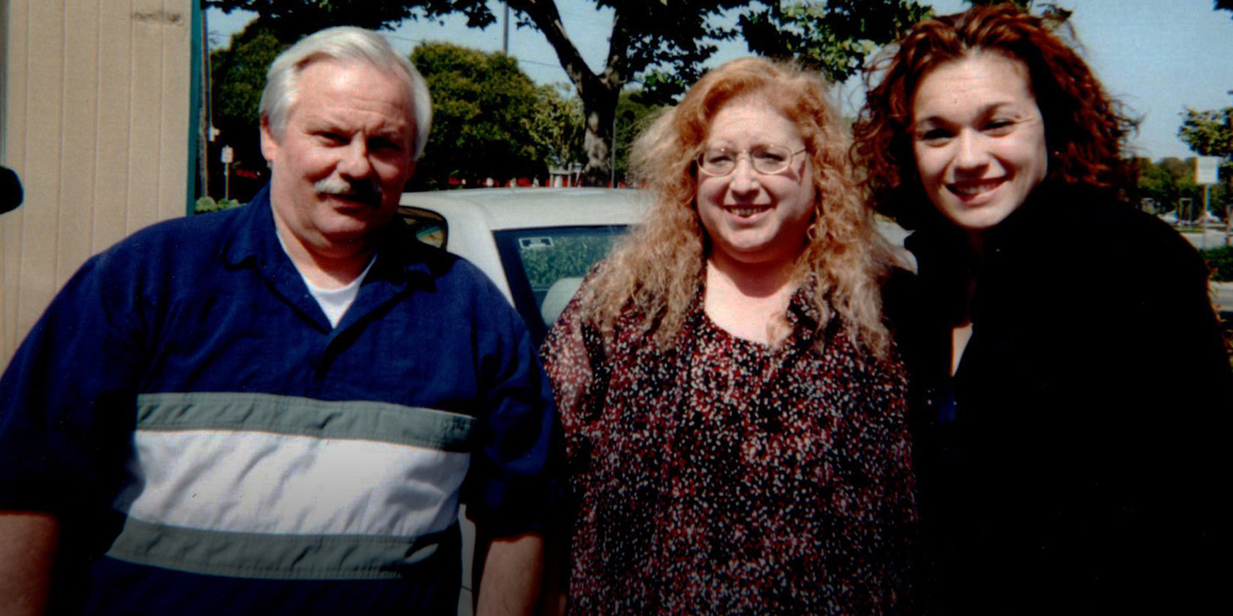 Michelle stands with her father and mother.