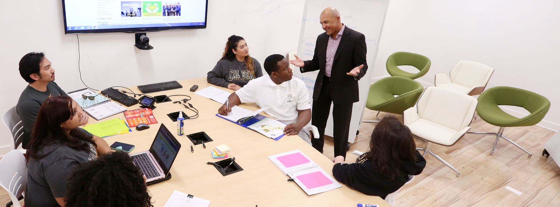students listening to a professor in a computer lab